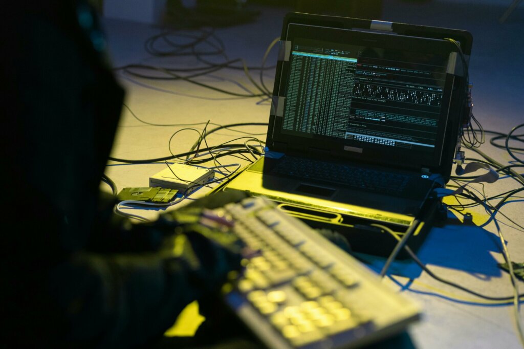 Un ordinateur portable affichant des lignes de code, représentant une cyberattaque par ransomware, dans une ambiance sombre et technologique.