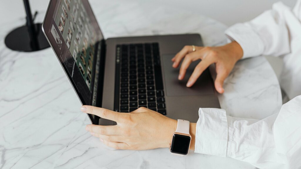 Collaboratrice utilisant un ordinateur portable pour gérer un portail digital de supply chain, symbole de la collaboration et de la transparence entre fournisseurs.