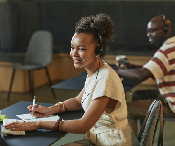 Employée de PME utilisant un outil CRM pour gérer la relation client depuis un centre de support